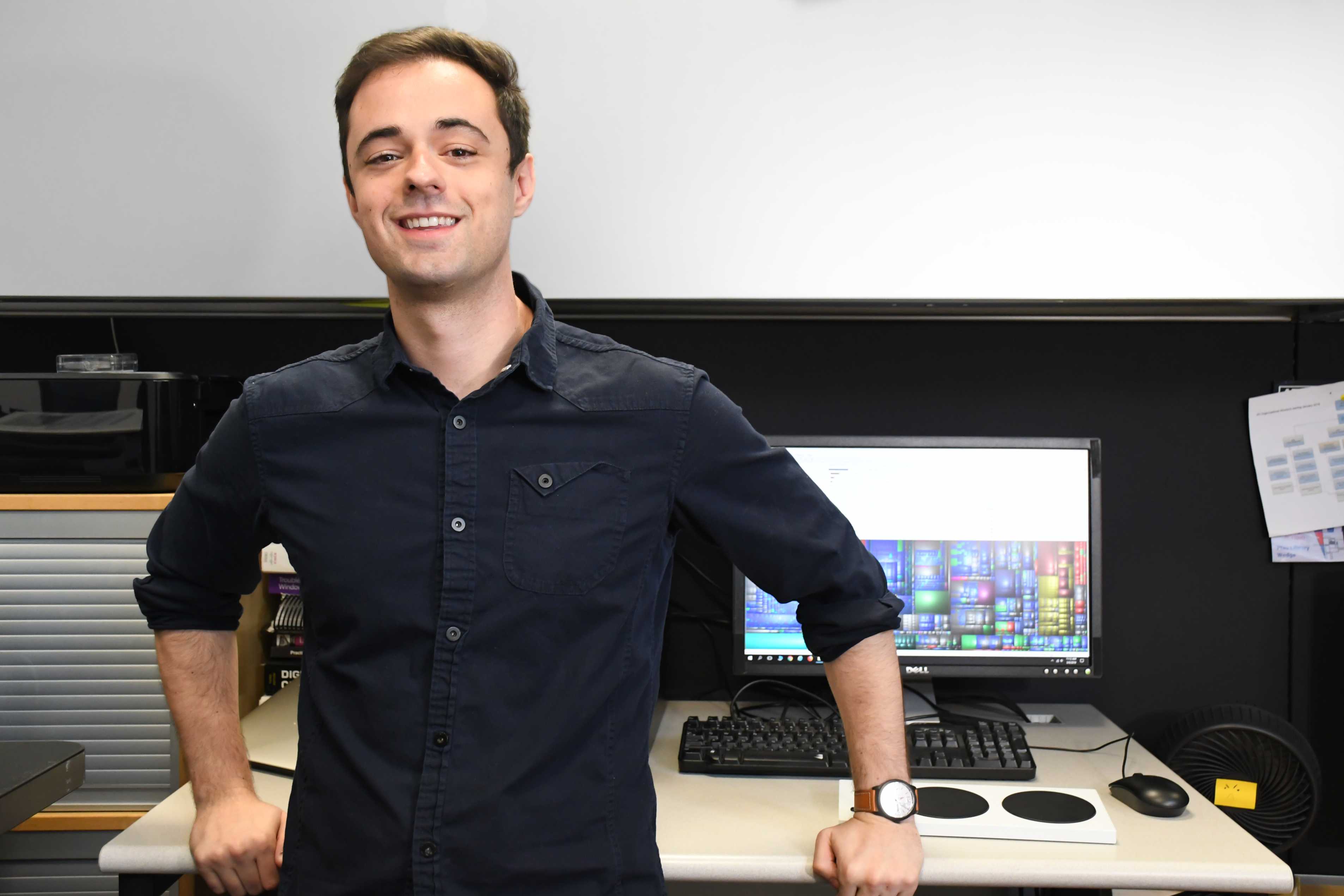 Kevin Cleppe in standing in front of a computer and an Xbox Adaptive Controller